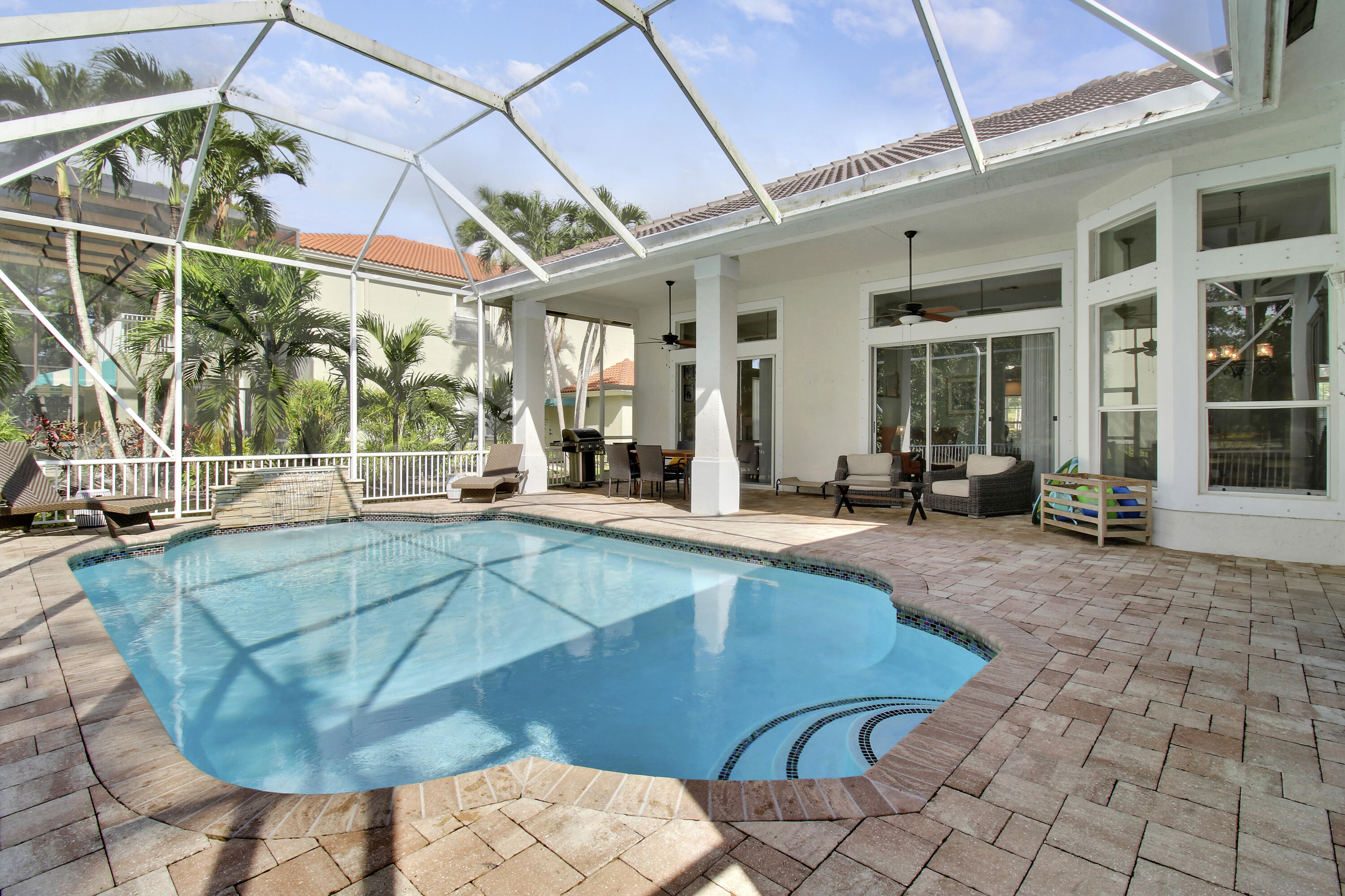 799 Cedar Cove Road Wellington, FL 33414 - Photo 35 of 44 a view of a patio with table and chairs potted plants and floor to ceiling window