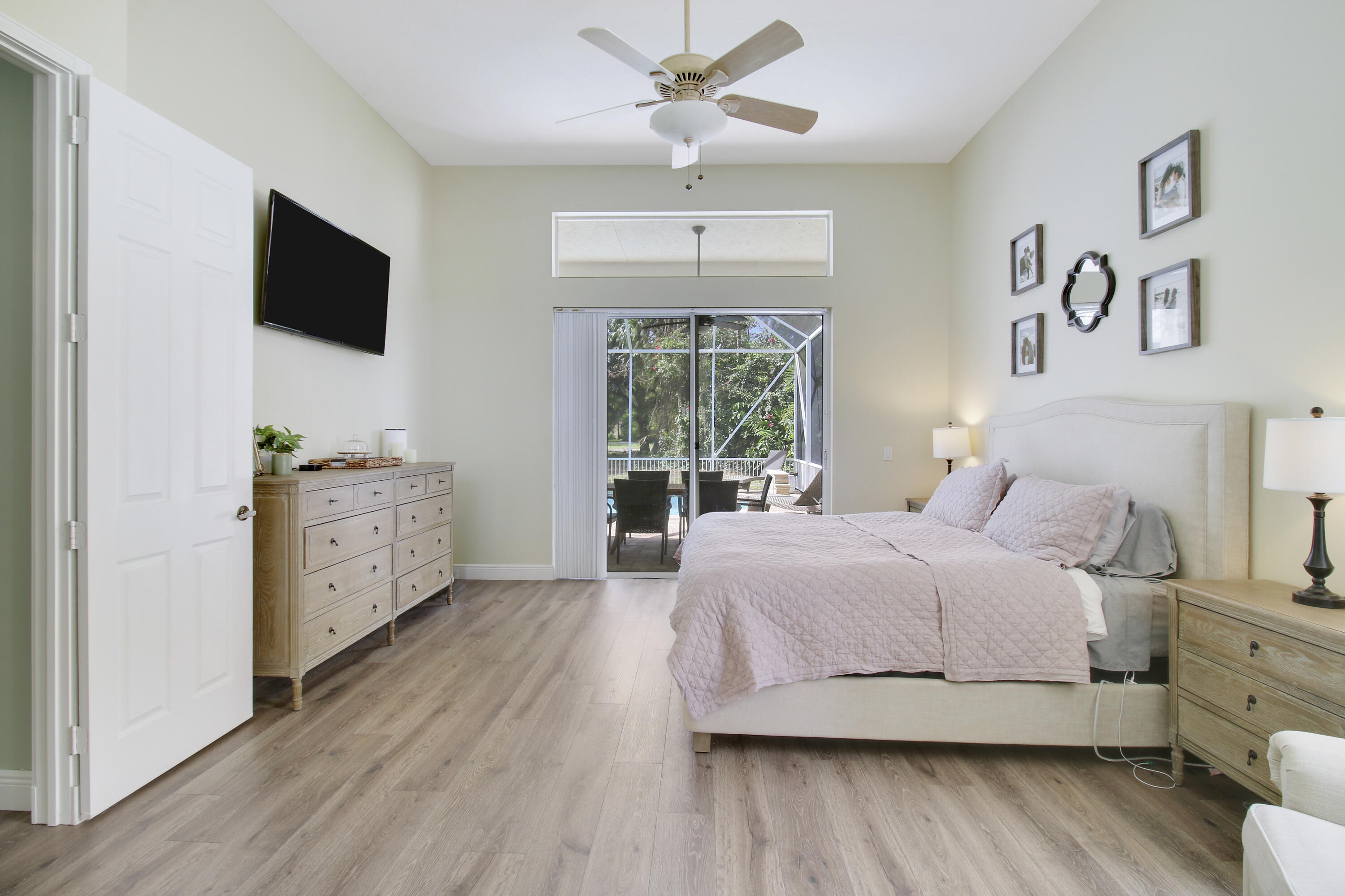 799 Cedar Cove Road Wellington, FL 33414 - Photo 10 of 44 a spacious bedroom with a large bed and a flat tv screen on dresser