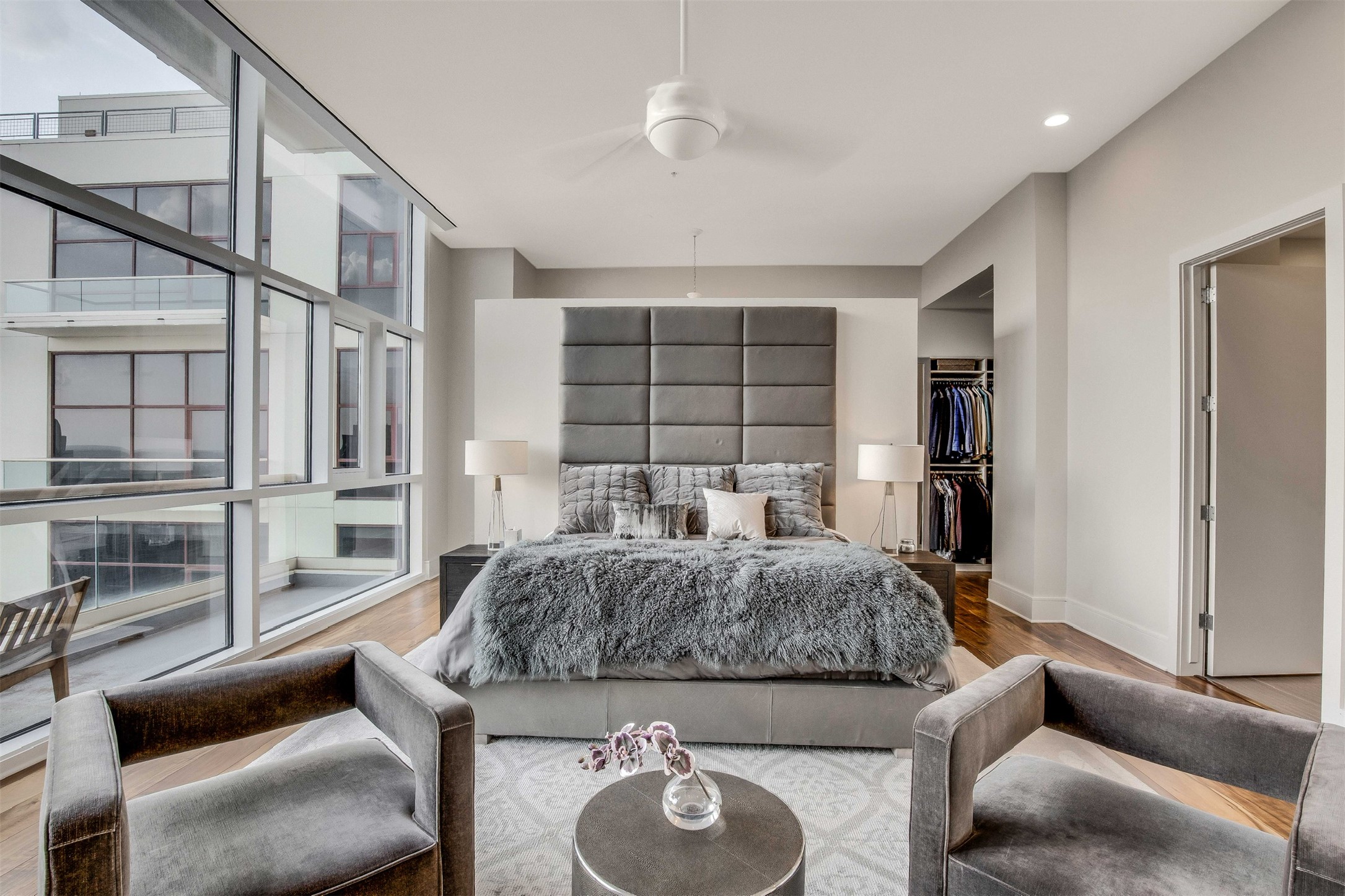 555 East 5th Street, Unit 3022 Austin, TX 78701 - Photo 18 of 40 Bedroom featuring a spacious closet, wood finished floors, expansive windows, and ceiling fan