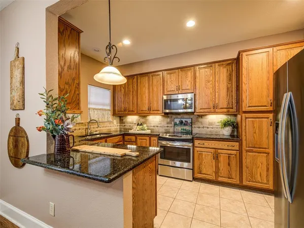 a kitchen with stainless steel appliances granite countertop a sink a stove and a refrigerator