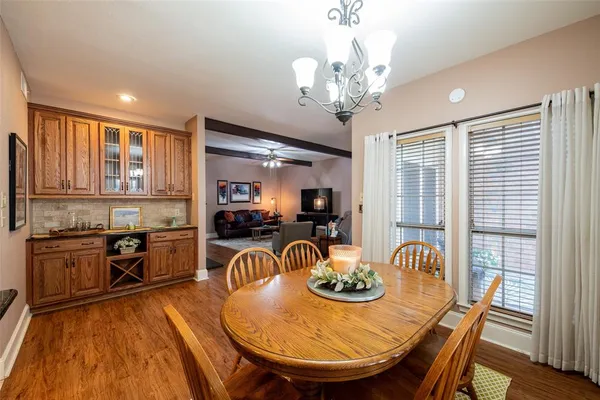 a view of a dining room with furniture a chandelier and wooden floor