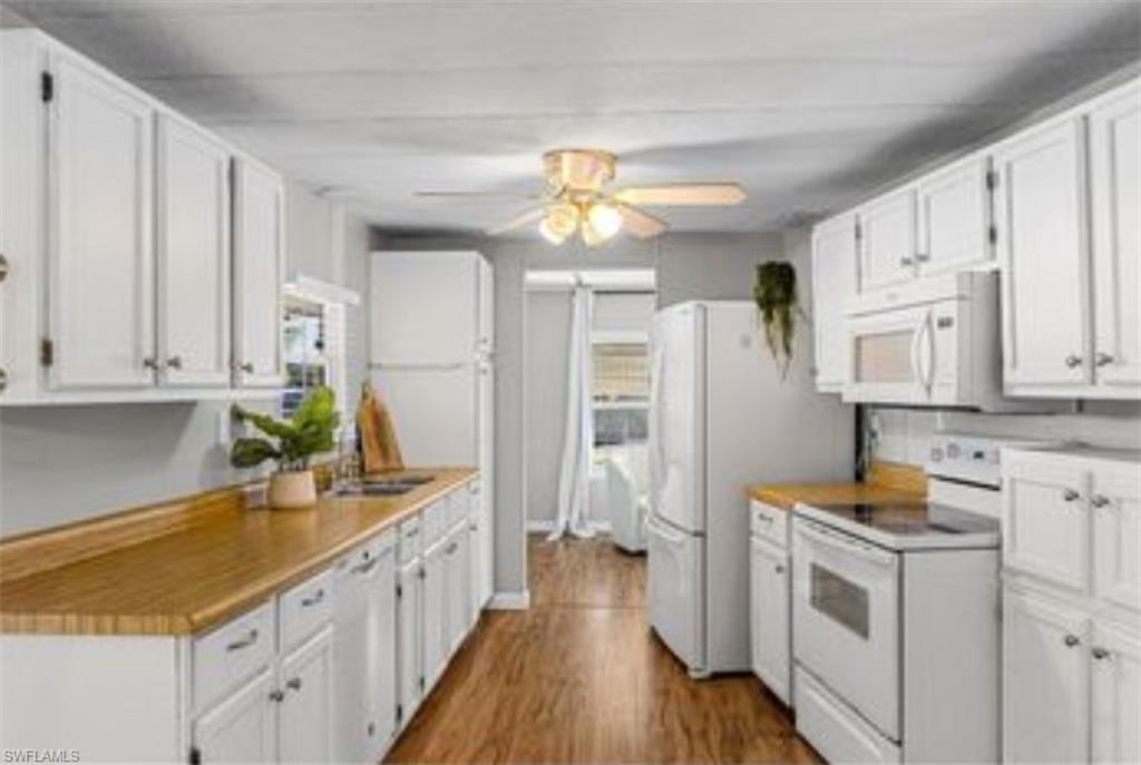 407 Cape Florida Way Naples, FL 34104 - Photo 12 of 27 Kitchen featuring white cabinets, white appliances, dark wood-style floors, and light countertops