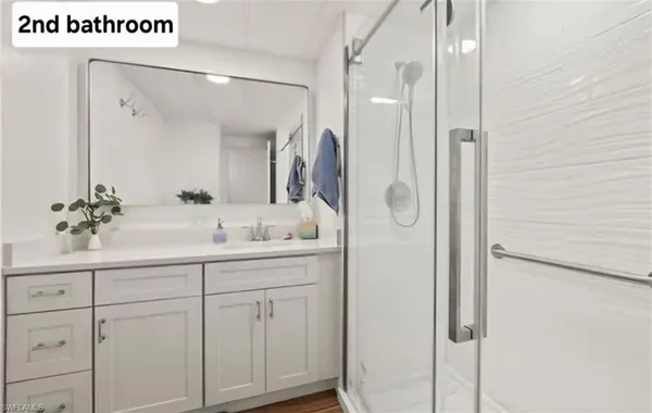 a bathroom with a shower sink and mirror