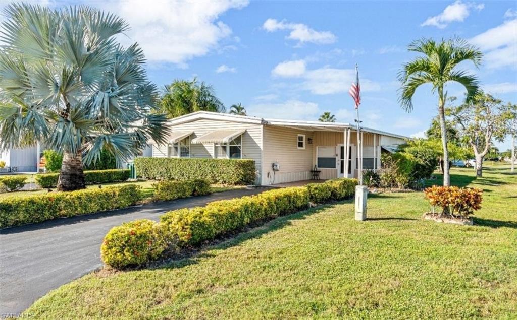 407 Cape Florida Way Naples, FL 34104 - Photo 19 of 27 View of front of house featuring a front lawn, a carport, and covered porch
