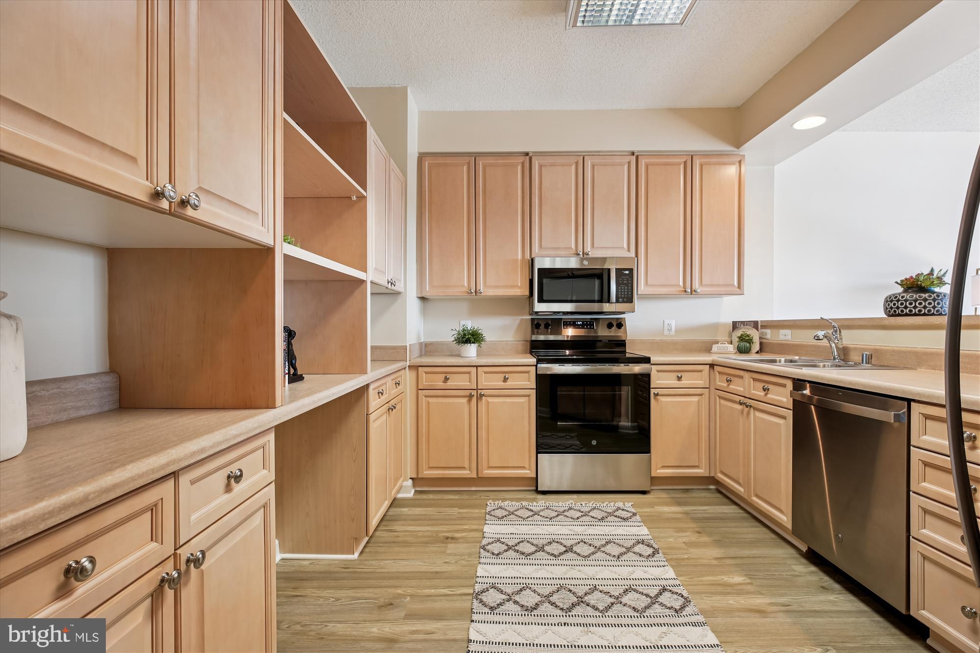 3005 South Leisure World Boulevard, Unit 802 Silver Spring, MD 20906 - Photo 16 of 70 a kitchen with granite countertop a sink cabinets stainless steel appliances and a counter space