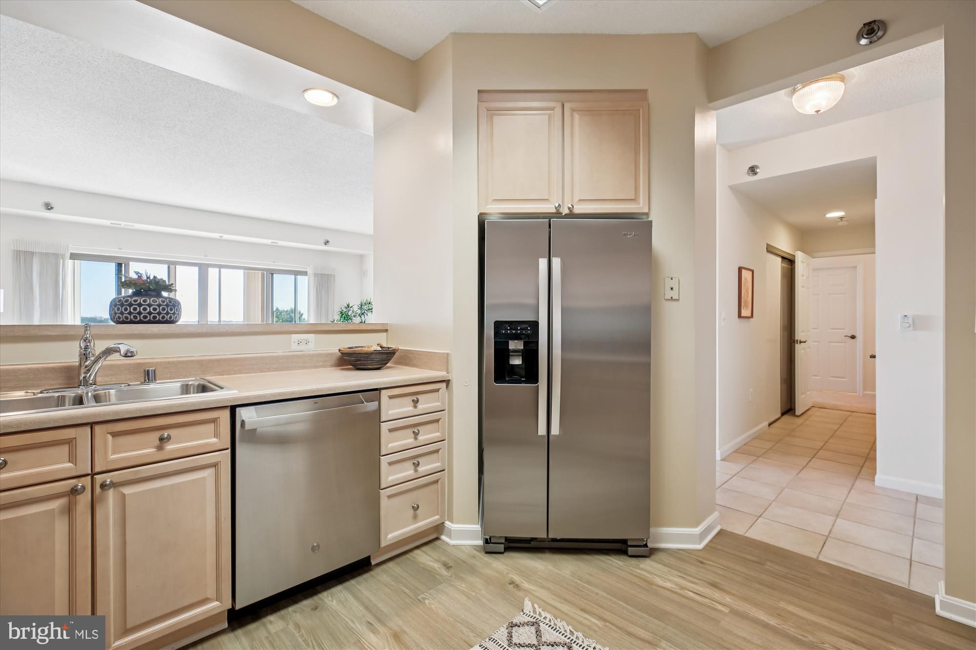 3005 South Leisure World Boulevard, Unit 802 Silver Spring, MD 20906 - Photo 20 of 70 a kitchen with a refrigerator sink and cabinets