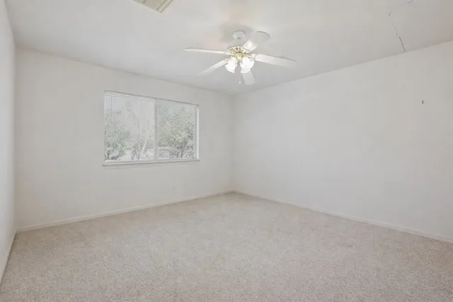 an empty room with a chandelier fan