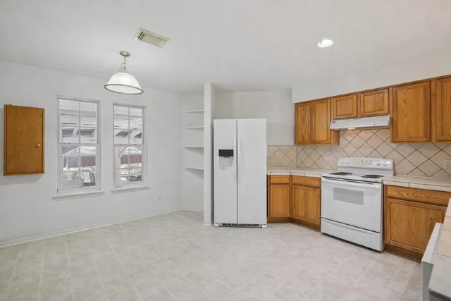 a kitchen with stainless steel appliances granite countertop a stove a sink and a refrigerator