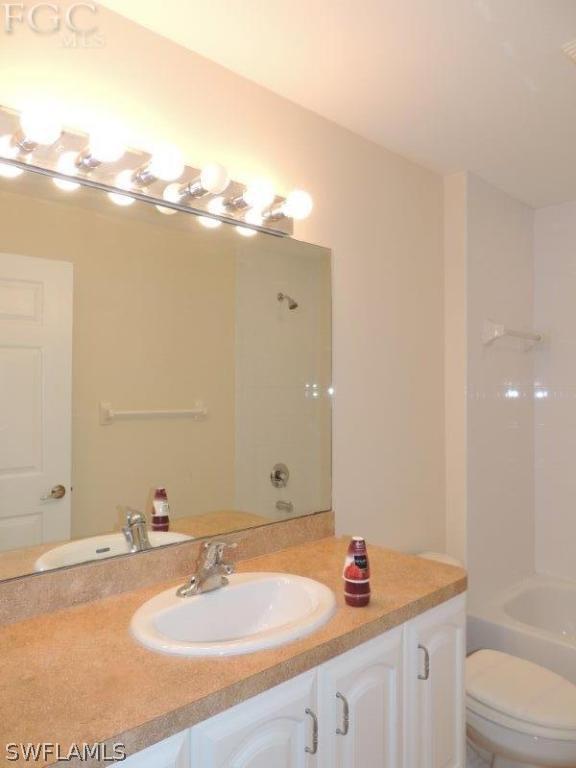 2280 Somerset Ridge Drive, Unit 101 Lehigh Acres, FL 33973 - Photo 7 of 12 a bathroom with a granite countertop sink and a mirror