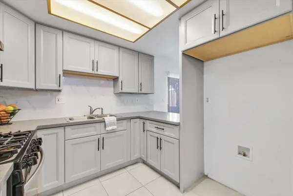 a kitchen with white cabinets stainless steel appliances and sink