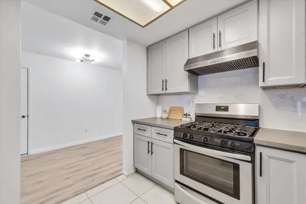 a kitchen with white cabinets and appliances