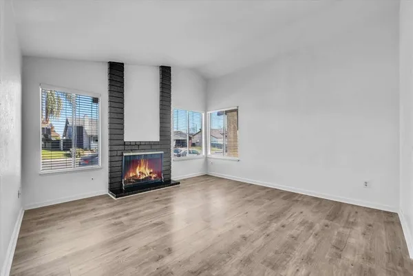 a view of empty room with fireplace and wooden floor