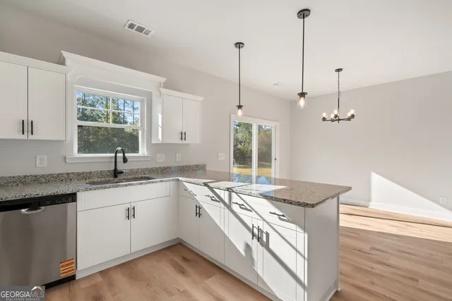 a kitchen that has a sink a stove and a wooden floor