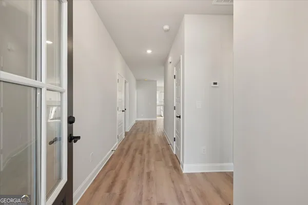 a view of a hallway with wooden floor