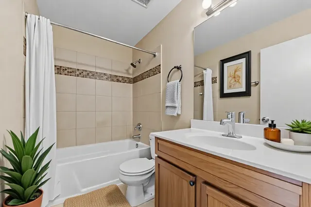 a bathroom with a sink a toilet a tub and shower