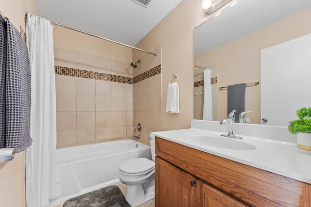 a bathroom with a sink a toilet a mirror and shower