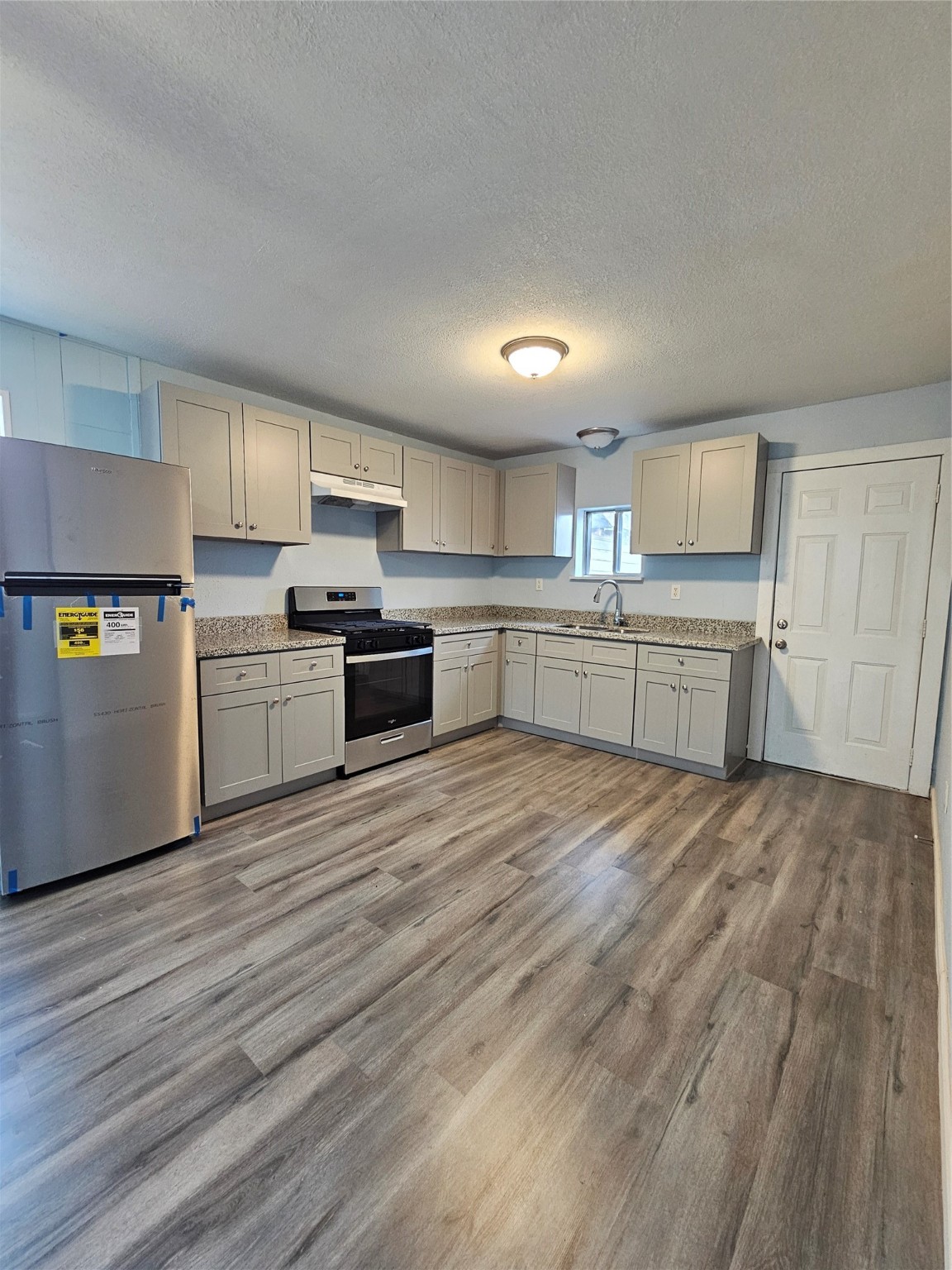 a kitchen with a cabinets wooden floor and stainless steel appliances
