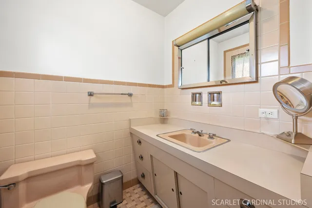 a bathroom with a sink a toilet and a mirror