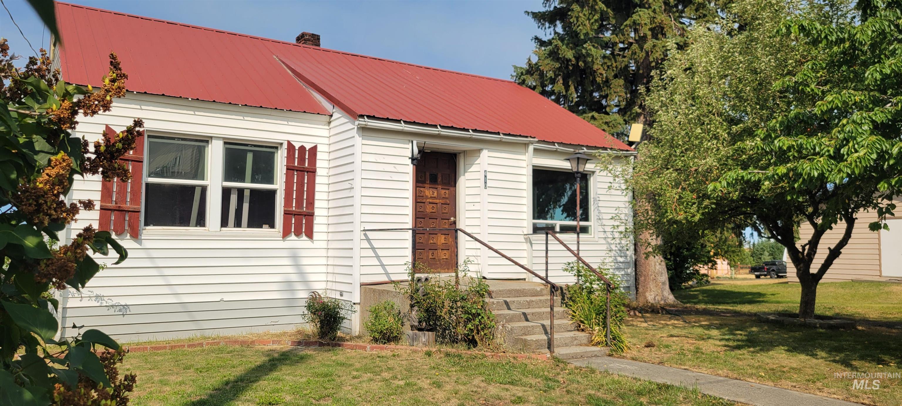 410 Division Avenue Craigmont, ID 83523 - Photo 1 of 30 View of front of property with a front yard, a metal roof, and a chimney