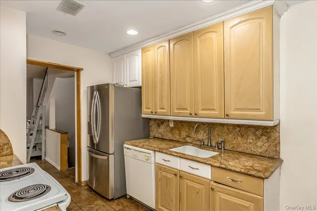 a kitchen with stainless steel appliances granite countertop a refrigerator and a stove