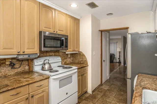 a kitchen with stainless steel appliances granite countertop a stove a sink and a microwave