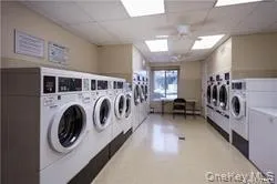 a utility room with dryer washer and a view of living room