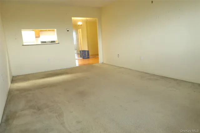 an empty room with windows and painting on the wall