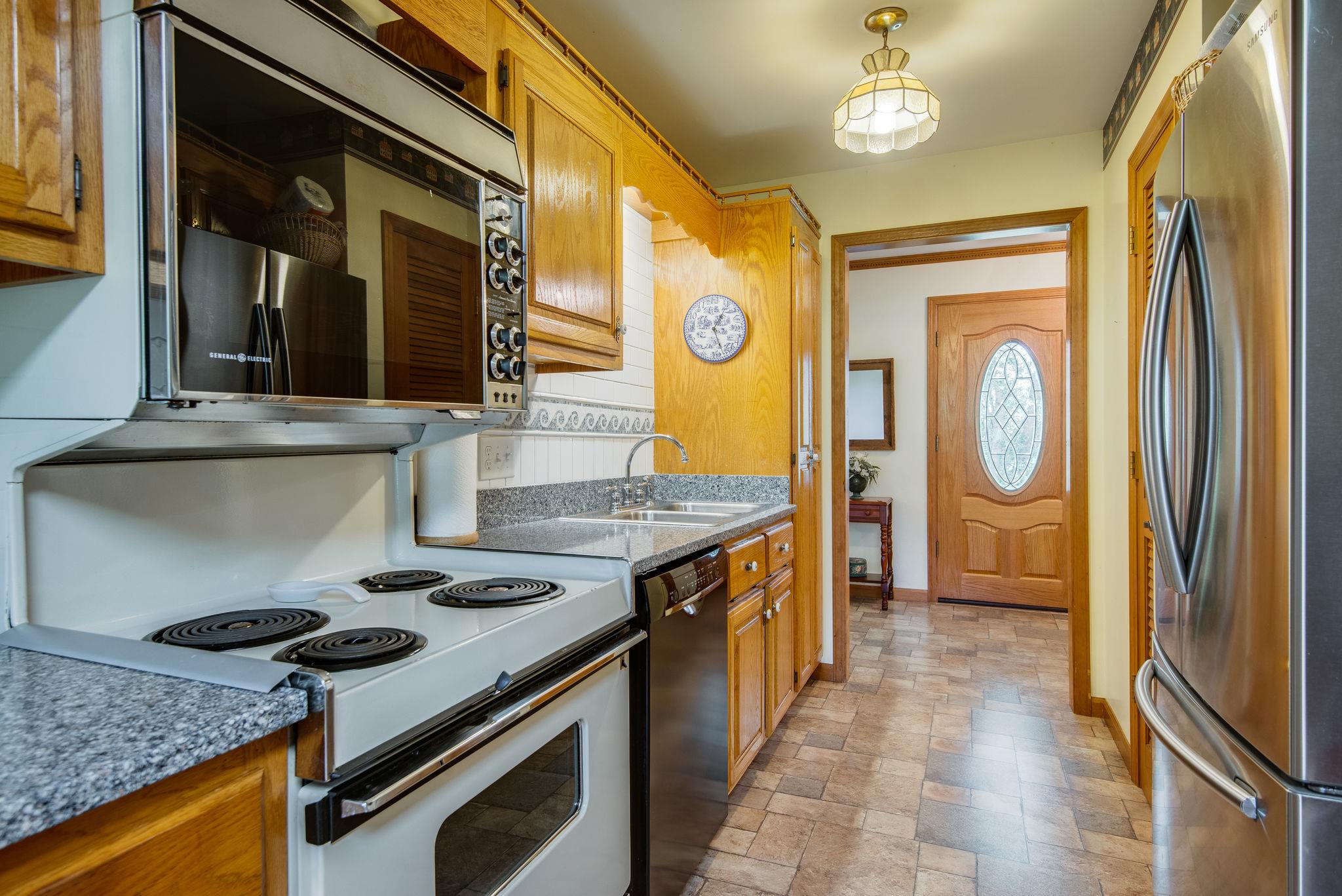 7357 Swift Road Greenbrier, TN 37073 - Photo 11 of 30 a kitchen with granite countertop a stove and a refrigerator
