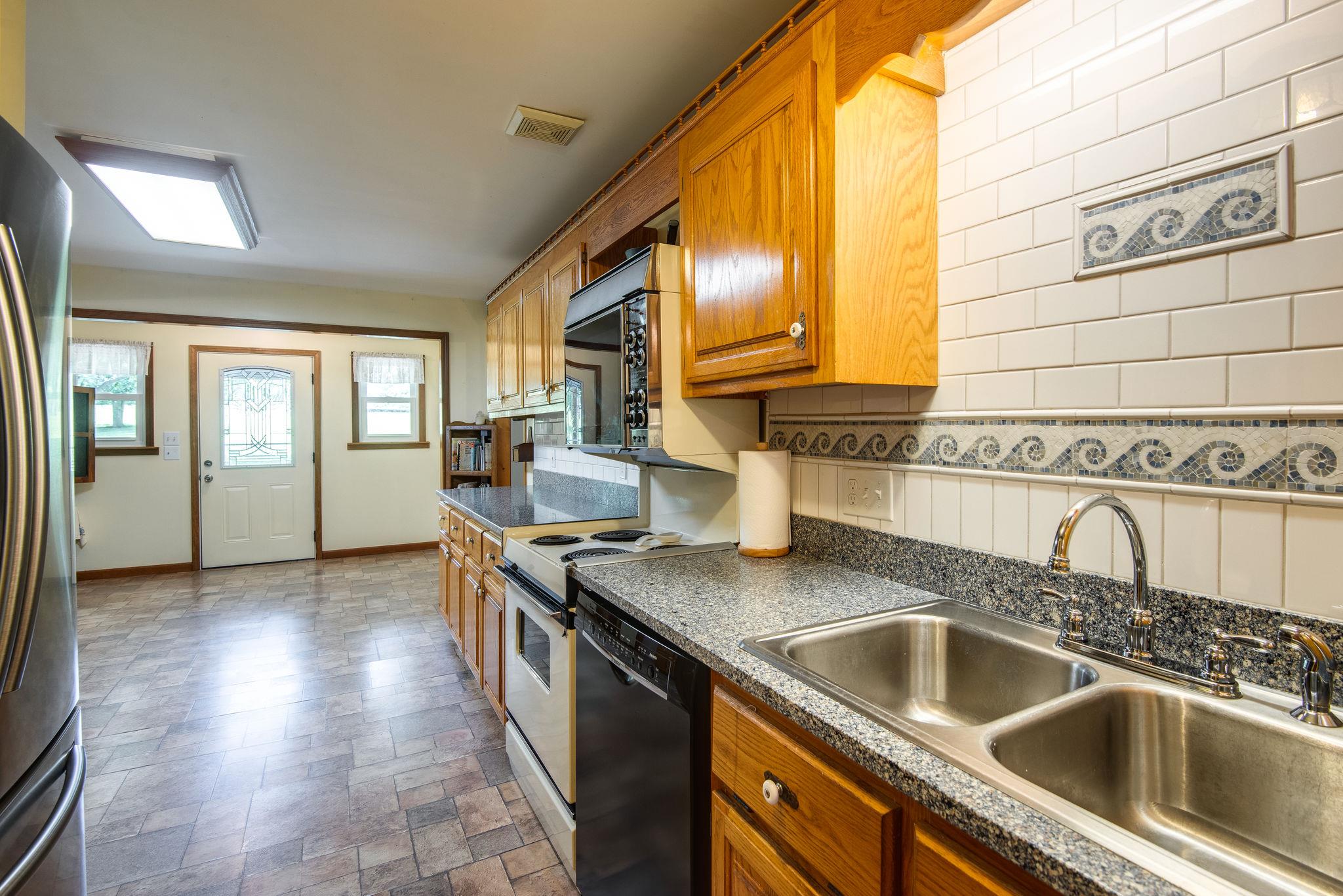 7357 Swift Road Greenbrier, TN 37073 - Photo 12 of 30 a kitchen with stainless steel appliances granite countertop a sink and a wooden cabinets