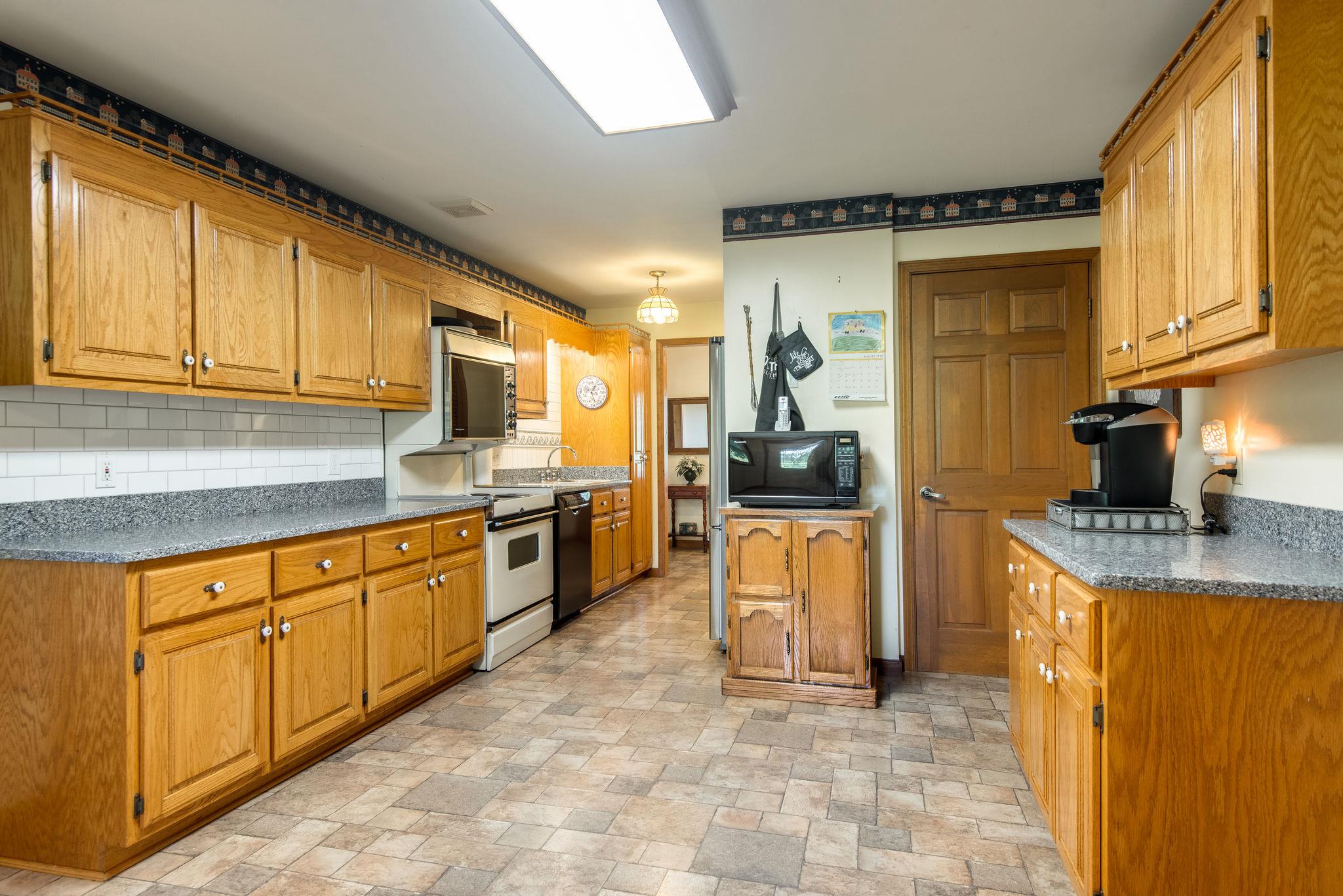 7357 Swift Road Greenbrier, TN 37073 - Photo 10 of 30 a kitchen with stainless steel appliances granite countertop a stove a sink and a microwave
