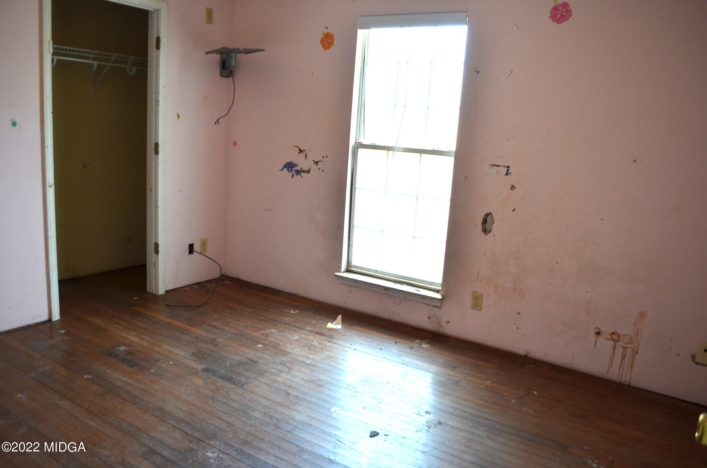 1754 Cummings Road Fort Valley, GA 31030 - Photo 15 of 28 an empty room with wooden floor and windows