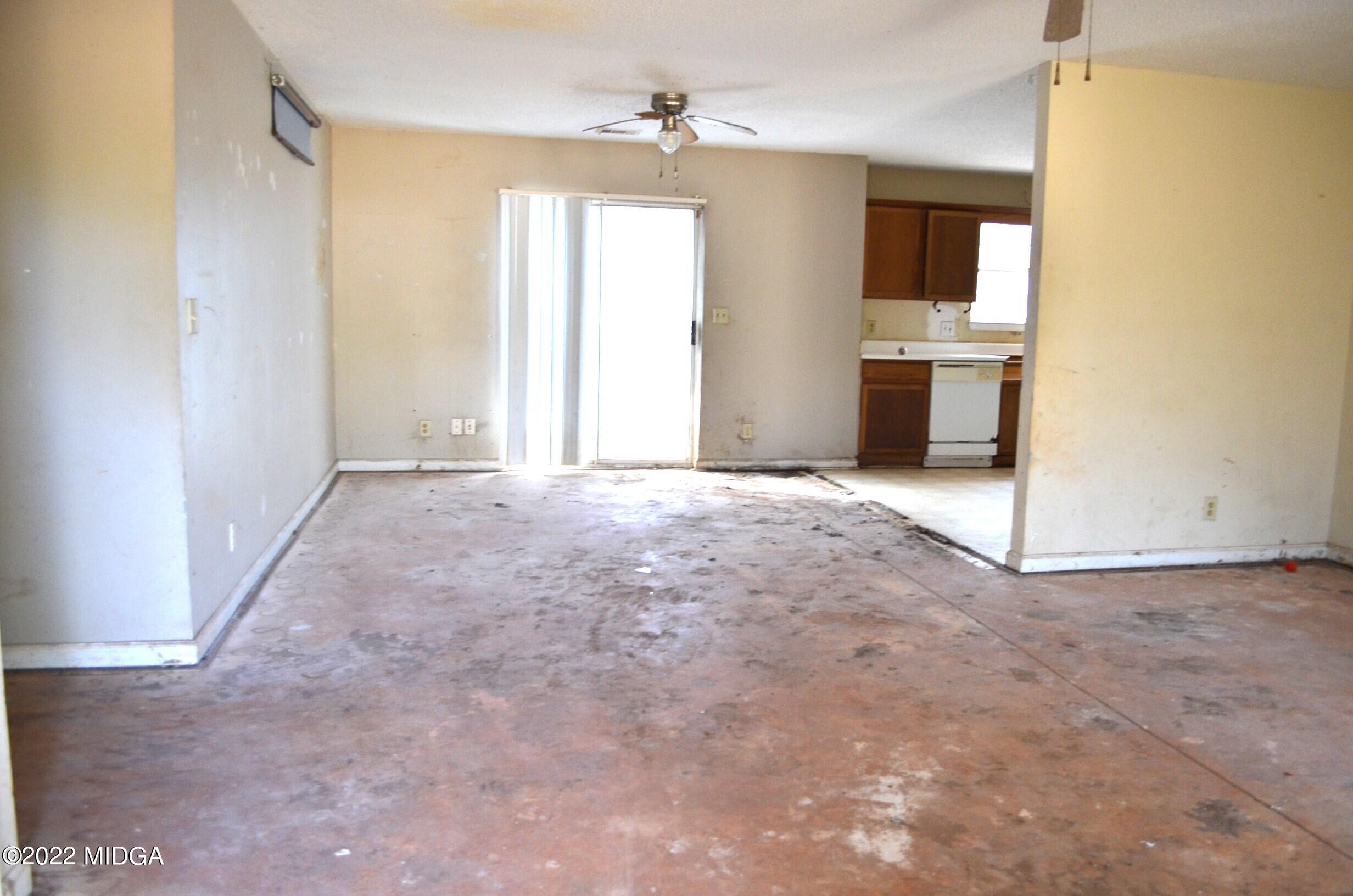 1754 Cummings Road Fort Valley, GA 31030 - Photo 6 of 28 an empty room with windows and fireplace