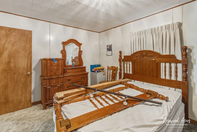 a bedroom with a bed and dresser with mirror