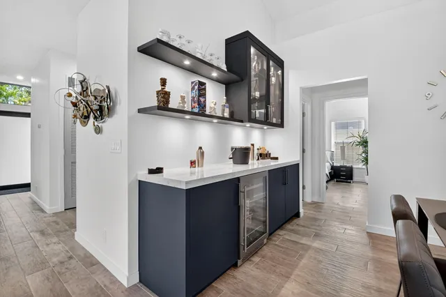 a open dining room with stainless steel appliances kitchen island granite countertop a table chairs and a refrigerator