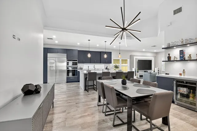 a large kitchen with kitchen island a large counter space a sink stainless steel appliances and cabinets