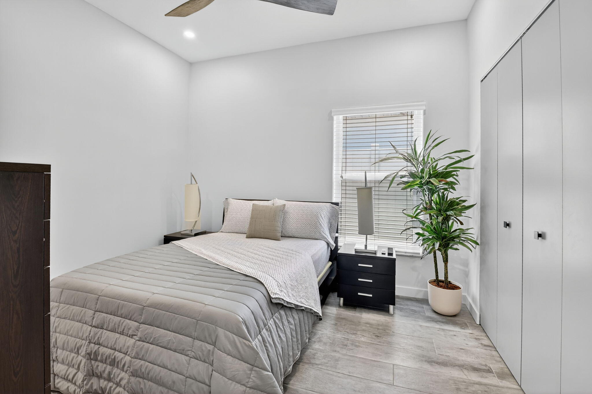 494 Enfield Court Delray Beach, FL 33444 - Photo 31 of 78 a bedroom with a bed and a potted plant