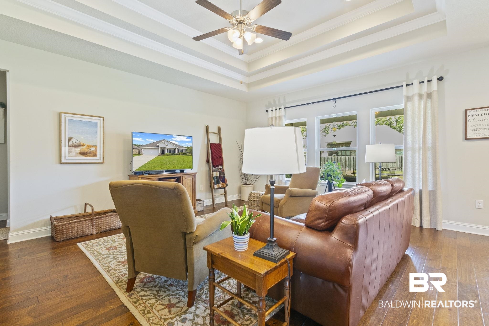 31663 Kestrel Loop Daphne, AL 36527 - Photo 16 of 86 Living room with crown molding, dark wood-type flooring, ceiling fan, and a tray ceiling