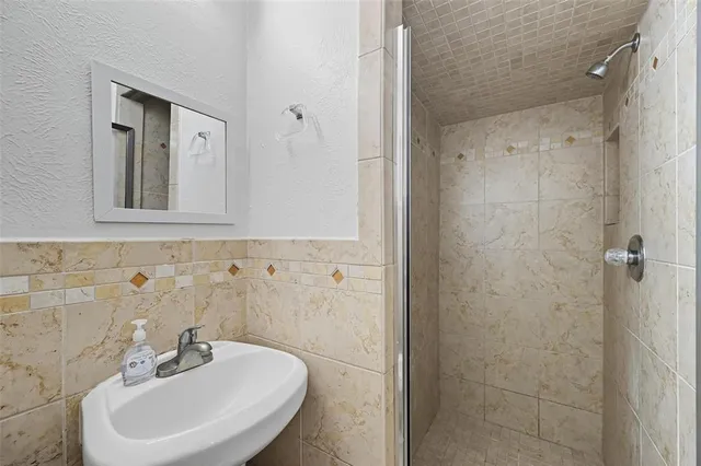 a bathroom with a sink a mirror and shower