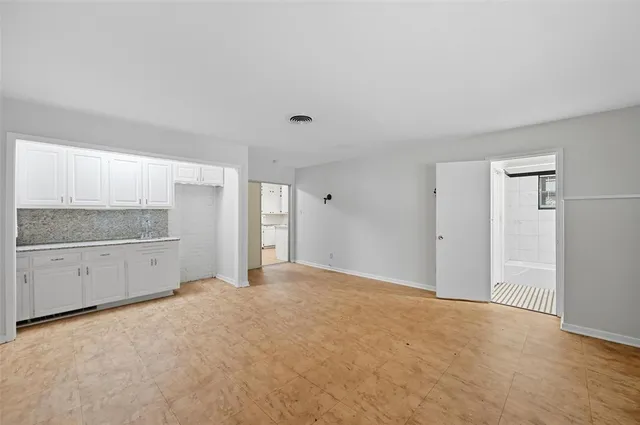 a view of an empty room with window and cabinet