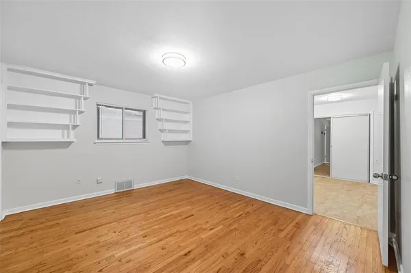 a view of empty room with wooden floor