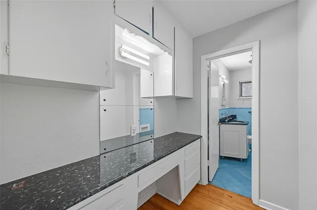 a kitchen with granite countertop white cabinets and white appliances