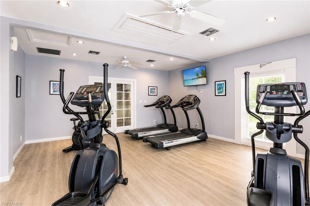 600 Neapolitan Way, Unit 449 Naples, FL 34103 - Photo 25 of 44 Dedicated fitness space featuring wood-finish flooring and light gray walls
