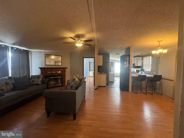 a living room with furniture and a dining table with kitchen view