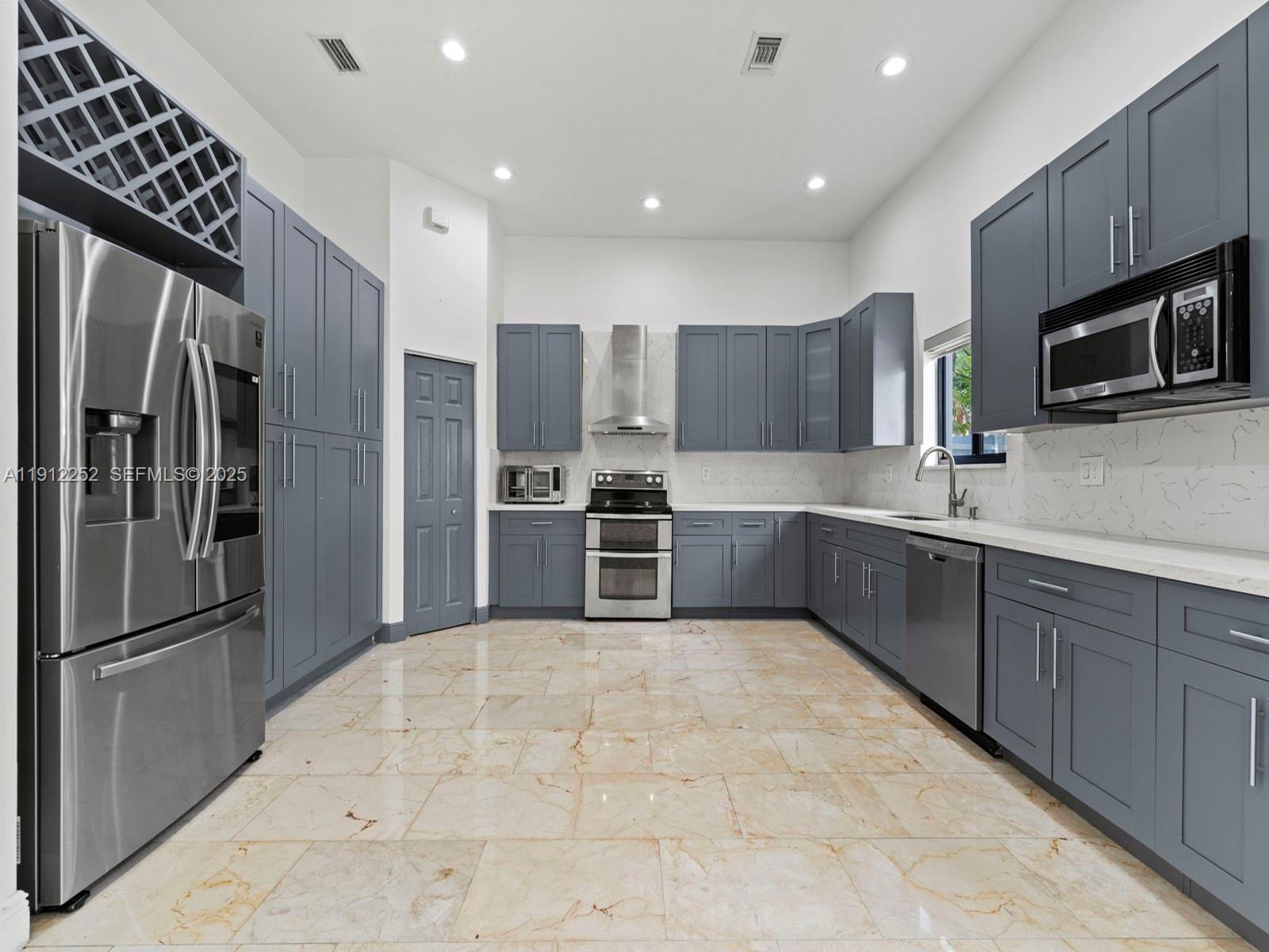 15871 Southwest 141st Street Miami, FL 33196 - Photo 11 of 41 a kitchen with stainless steel appliances granite countertop a refrigerator and a sink
