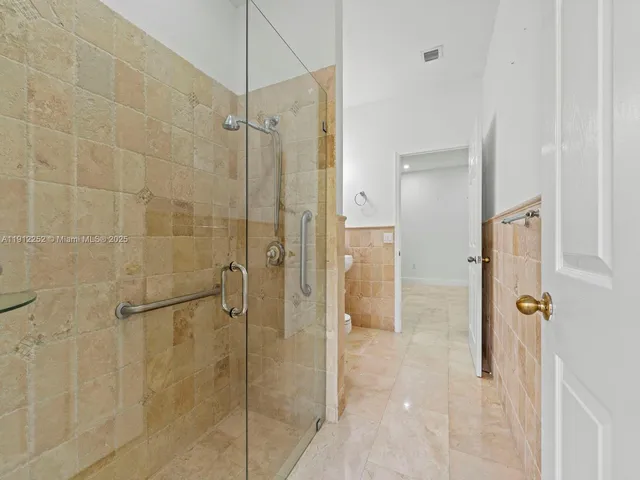 a bathroom with a shower and a glass door