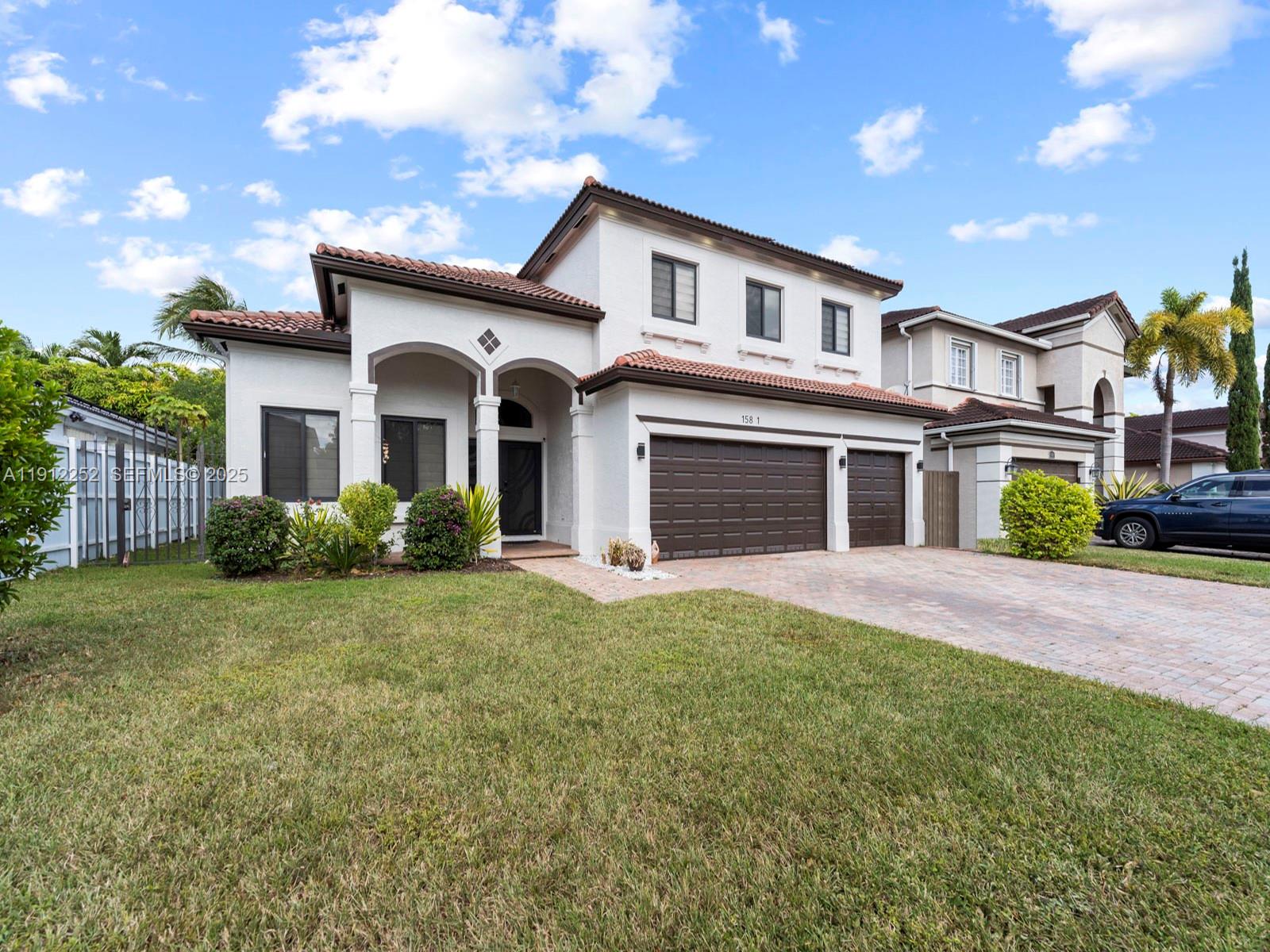 15871 Southwest 141st Street Miami, FL 33196 - Photo 2 of 41 a front view of a house with a garden and yard