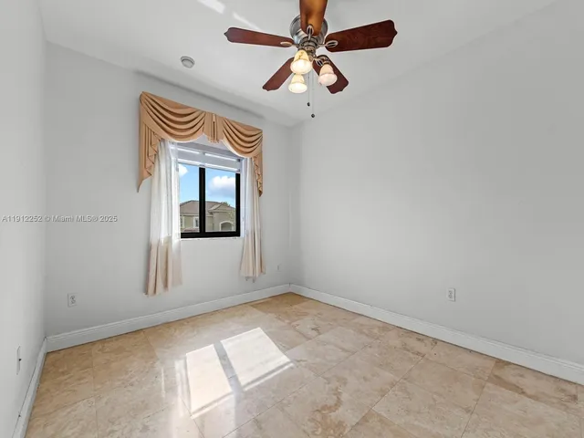 an empty room with a chandelier fan