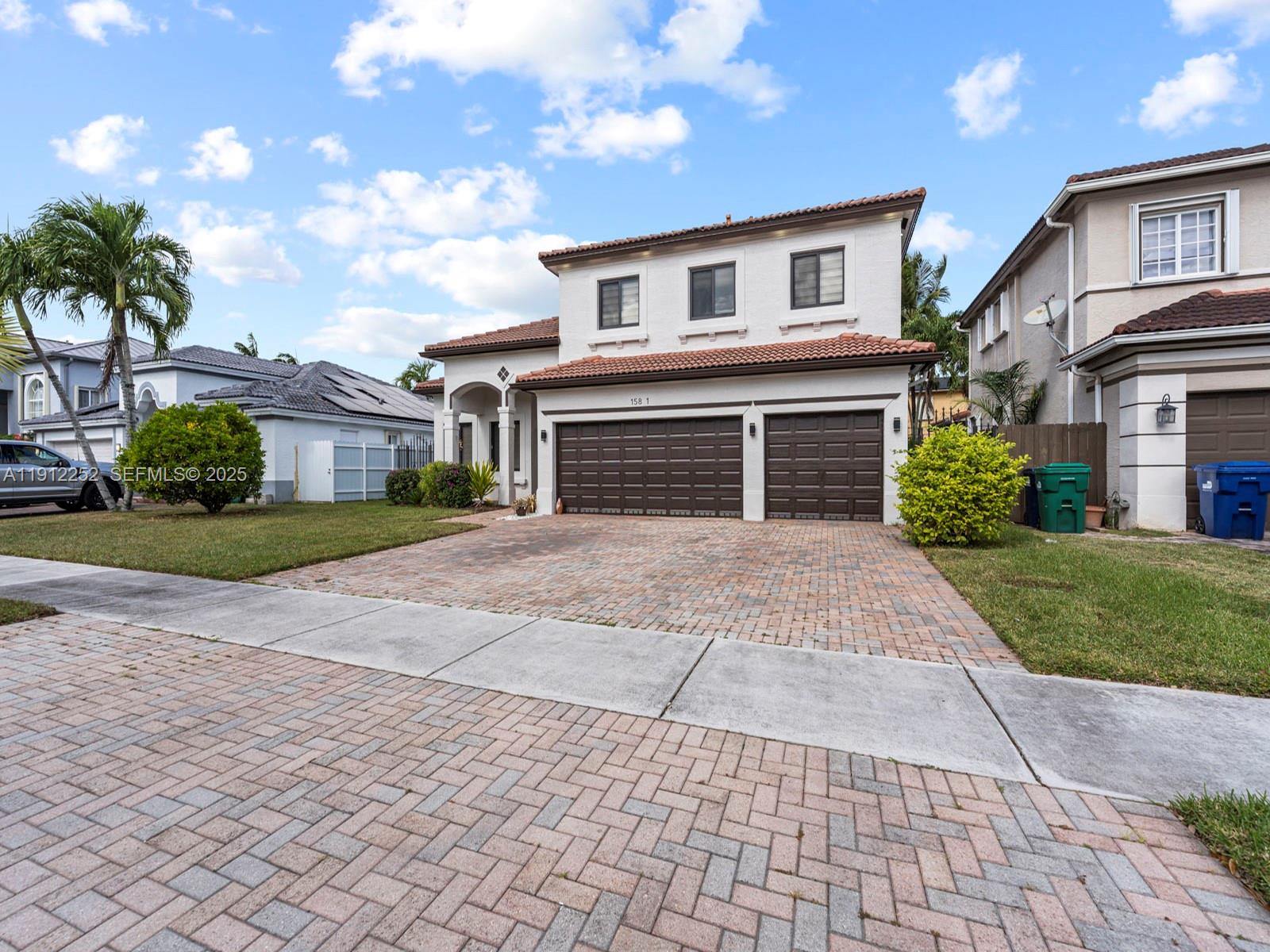 15871 Southwest 141st Street Miami, FL 33196 - Photo 3 of 41 a front view of a house with a yard and potted plants