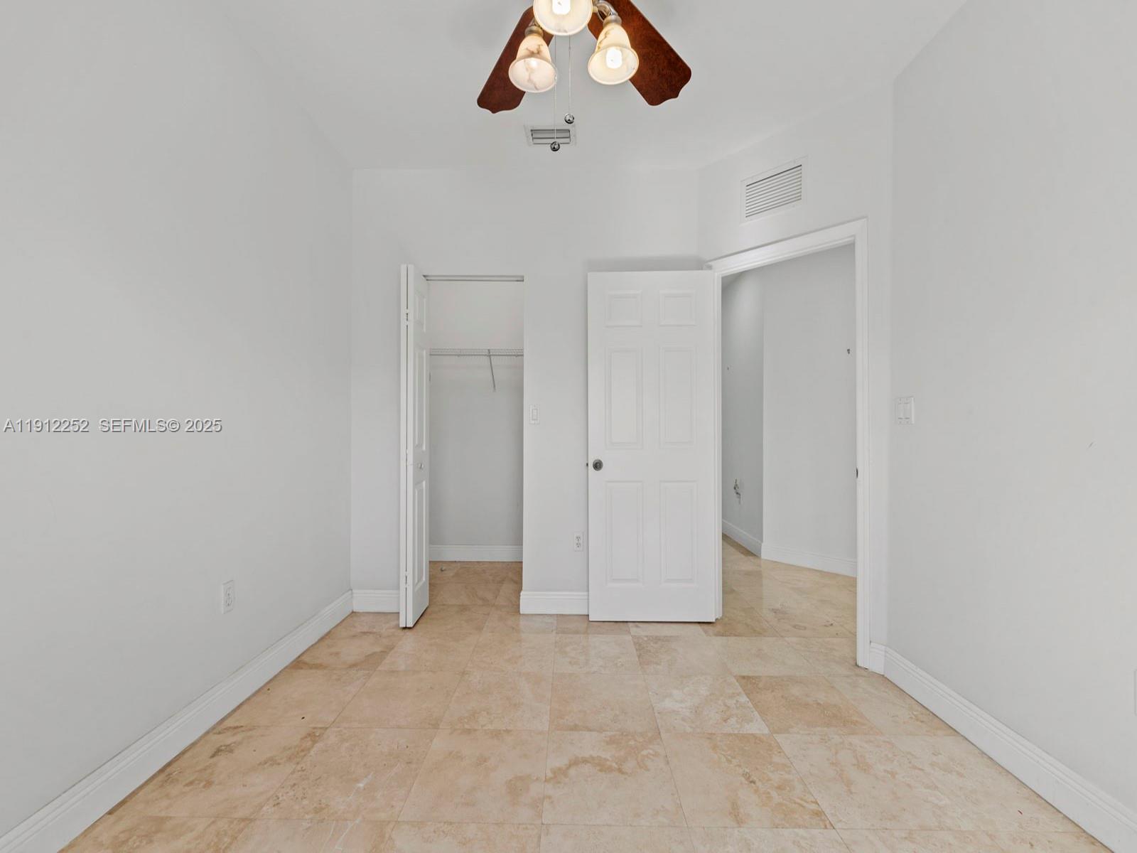 15871 Southwest 141st Street Miami, FL 33196 - Photo 31 of 41 an empty room with a chandelier fan