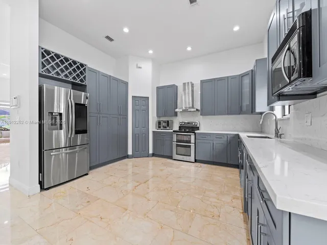 a kitchen with stainless steel appliances granite countertop a refrigerator sink and microwave